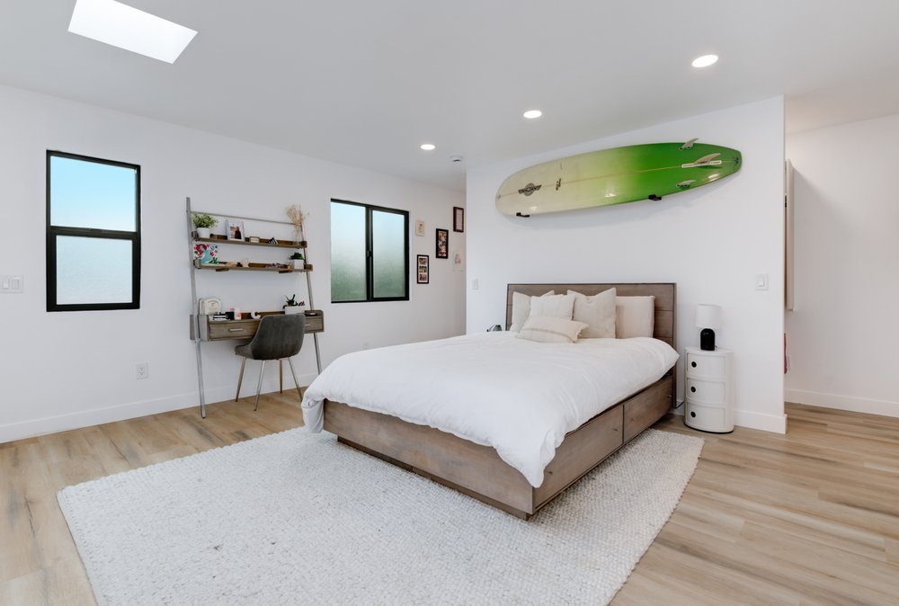 JADU primary bedroom, light oak floors, calm palette